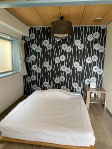 um quarto com uma cama e uma parede em preto e branco em Oyado Cocochi em Tóquio