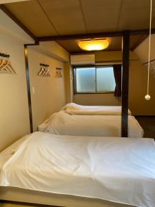 a bedroom with a bed and a window at Oyado Cocochi in Tokyo
