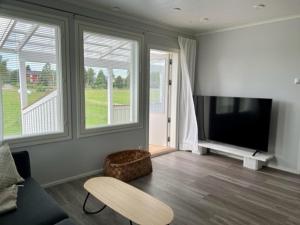 Soda Home - Hillside House - 24h check in في Närpiö: غرفة معيشة مع تلفزيون بشاشة مسطحة وأريكة