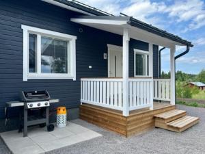 Soda Home - Hillside House - 24h check in في Närpiö: منزل أزرق صغير به شواية وشرفة