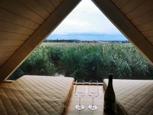 a pair of wine glasses and a bottle in a tent at Pfahlbau Sunset I Toplage Elektroboot inklusive in Rust