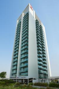 a tall white building with many balconies on it at Millennium Executive Apartments Mont Rose in Dubai