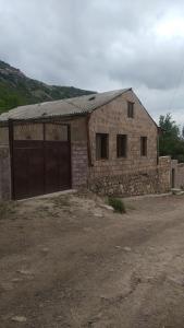 a brick building with a gate and a garage at Syunyats guest house in Halidzor
