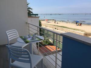 balcón con mesa y sillas y la playa en Appartamento Nadia, en Porto Cesareo
