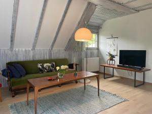 a living room with a green couch and a table at Ferienwohnung im Daungarten in Oberfell