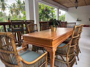 Naia Lombok في كوتا لومبوك: غرفة طعام مع طاولة وكراسي خشبية