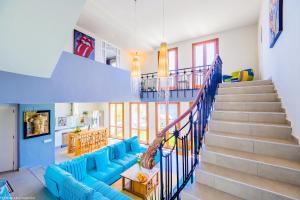 a living room with a blue couch and stairs at MIMAR ALTEA SOL urban in Altea