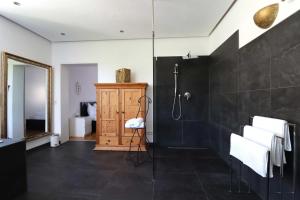 La salle de bains est pourvue d'une douche et de carrelage noir. dans l'établissement Konstanzer Ferienwohnungen, à Constance