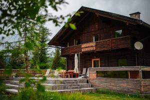 drewniany domek z werandą i schodami przed nim w obiekcie Marktlhütte w mieście Hochrindl