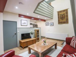 a living room with a couch and a table at Ysgubor Bach in Gaerwen