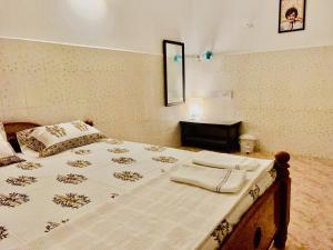 a bedroom with a bed and a table in it at La Ruelle Guest House in Puducherry