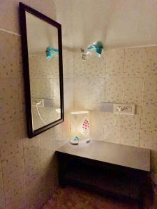 a bathroom with a mirror and a counter with a sink at La Ruelle Guest House in Puducherry