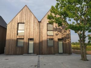 a timber clad house with a wooden facade at Pajūrio Ąžuolo Istorija 10 in Palanga