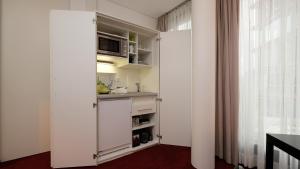 une cuisine avec une armoire blanche et une fenêtre dans l'établissement Wissenschaftszentrum Bonn, à Bonn