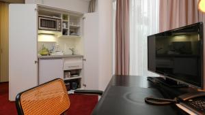 a room with a desk with a monitor and a chair at Wissenschaftszentrum Bonn in Bonn +4 photos