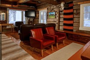 a living room with chairs and a flat screen tv at Kainuun Luontoretket in Hossa +19 photos
