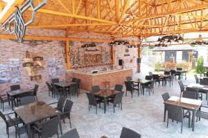 a restaurant with tables and chairs and a brick wall at Macara Sheki City Hotel in Sheki