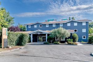 a hotel with a parking lot in front of it at Greet Hotel Bordeaux Floirac Arena in Floirac