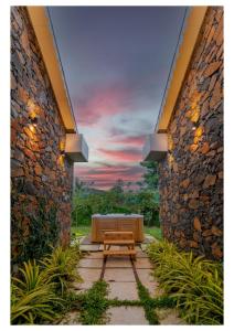 a patio with a bench and a sunset in the background at Stone Cold 2BHK in Nashik