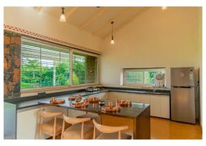 a kitchen with a table and chairs and a refrigerator at Stone Cold 2BHK in Nashik