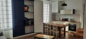 cocina con mesa y sillas en una habitación en Les lunettes d'Oyo 2 en Oyonnax