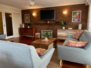 a living room with two couches and a tv at Salty Sands Meters From The Beach Free Wifi in Inverloch