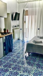 um quarto com piso em azulejo azul e uma cama em Vic e Vicariell em Gaeta