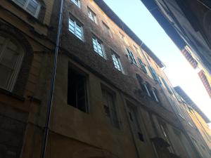 um edifício com janelas do lado em La conchiglia em Lucca