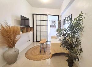 MarigondonにあるNEW Luxury Suite with pool and Netflix near Airportのリビングルーム(ソファ、テーブル、植物付)
