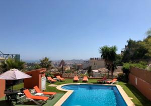 basen z leżakami i parasolami w budynku w obiekcie Cozy rooms in terraced house w mieście Fuengirola