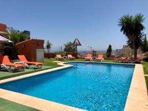 basen z pomarańczowymi krzesłami i ośrodek w obiekcie Cozy rooms in terraced house w mieście Fuengirola