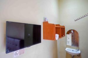 Solo的住宿－RedDoorz near Rumah Sakit Ortopedi Dr Soeharso，一间带壁挂式电视和水槽的浴室