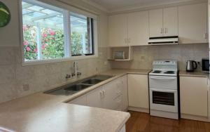 a kitchen with a sink and a stove at Salty Sands Meters From The Beach Free Wifi in Inverloch