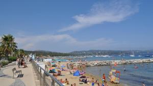 uma praia com um monte de pessoas na água em Spacious Marina & See view appartment em Cavalaire-sur-Mer
