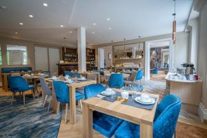 un comedor con mesas y sillas azules en Hôtel The Originals Résidence de Rohan (EX RELAIS DU SILENCE) en Vaux-sur-Mer