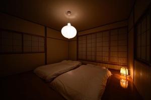 sypialnia z łóżkiem, lampką i lampką w obiekcie Taketori Roten -House with open-air bath w mieście Beppu