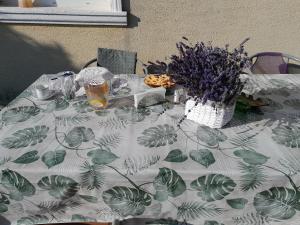 uma mesa com uma toalha de mesa branca com folhas verdes em Accommodation close to Budapest em Solymár