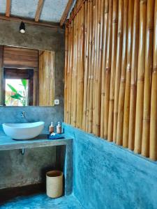 uma casa de banho com um lavatório e uma parede de madeira em Musa Bintang Villas and Bungalows Gili Air em Gili Air