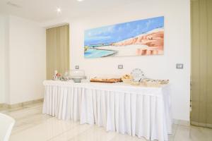 a white table with food on it in a room at Hotel La Mela in Varcaturo