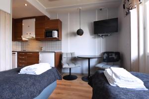 um quarto com 2 camas e uma cozinha com uma mesa em Levin Alppitalot Alpine Chalets Deluxe em Levi