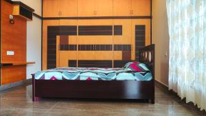 a bedroom with a bed with a wooden headboard at Padmanivas in Bangalore