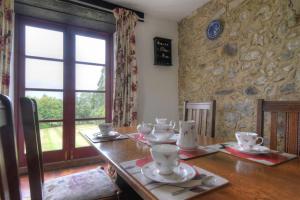 Rose Cottage في Musbury: غرفة طعام مع طاولة خشبية مع أطباق عليها