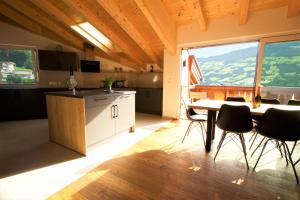 kuchnia ze stołem i krzesłami oraz duże okno w obiekcie Mountain Penthouse Top 8 & 9 w mieście Fügen