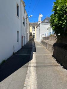 une rue vide avec des bâtiments blancs sur le côté dans l'établissement La Ruelle des Bords de Loire - Classé 2**, à Basse-Indre