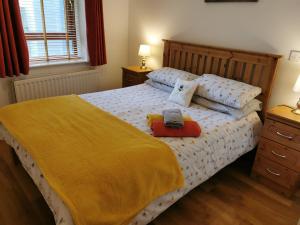 a bedroom with a bed with a yellow blanket and pillows at Erne View Apartments 1C - Lakeside Apartment Enniskillen in Enniskillen
