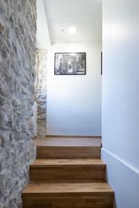 uma escada numa casa com uma parede de pedra em Apartments Rose em Cres