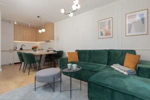salon z zieloną kanapą i stołem w obiekcie Apartment Wyspa Solna Kołobrzeg by Renters w Kołobrzegu