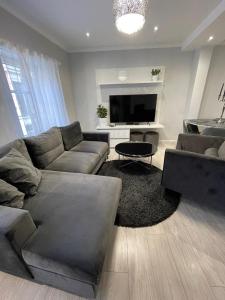 ein Wohnzimmer mit einem Sofa und einem Flachbild-TV in der Unterkunft Brother street apartment in Liepāja