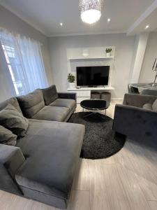 a living room with a couch and a flat screen tv at Brother street apartment in Liepāja