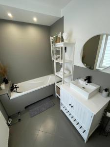 a bathroom with a tub and a sink and a mirror at Brother street apartment in Liepāja